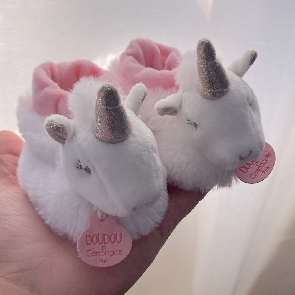 Baby girl white unicorn booties with pink trim on the inside and golden horn